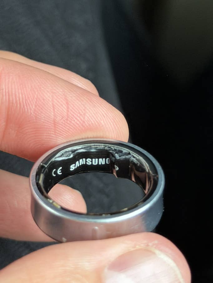 A person holding a Samsung Galaxy ring, showing the inside with 'SAMSUNG' engraved.