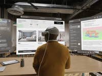 A person using the Apple Vision Pro virtual displays in the work station