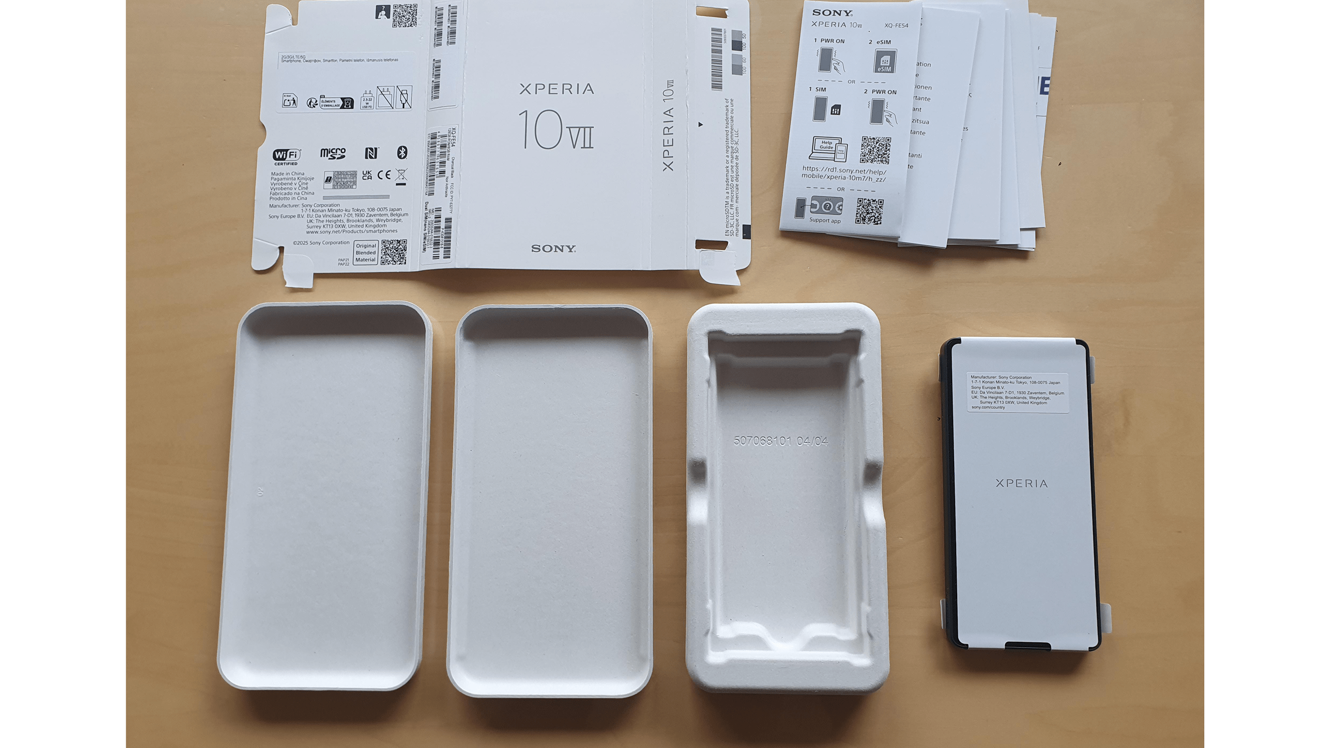 Sony Xperia 10 VII packaging with manuals, empty trays, and protective case.