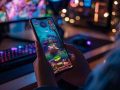 Mobile game on a smartphone screen with gaming room setting (AI generated)