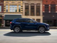 Toyota RAV4 2025 A blue Toyota RAV4 driving past historic buildings on a street.