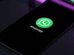 Ein Smartphone zeigt das WhatsApp-Logo auf einem schwarzen Bildschirm.