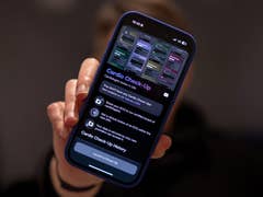 A person holding a smartphone displaying the 'Cardio Check-Up' app interface.