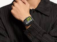 A hand wearing a Xiaomi Redmi Watch 5, displaying yellow and white digital numbers.