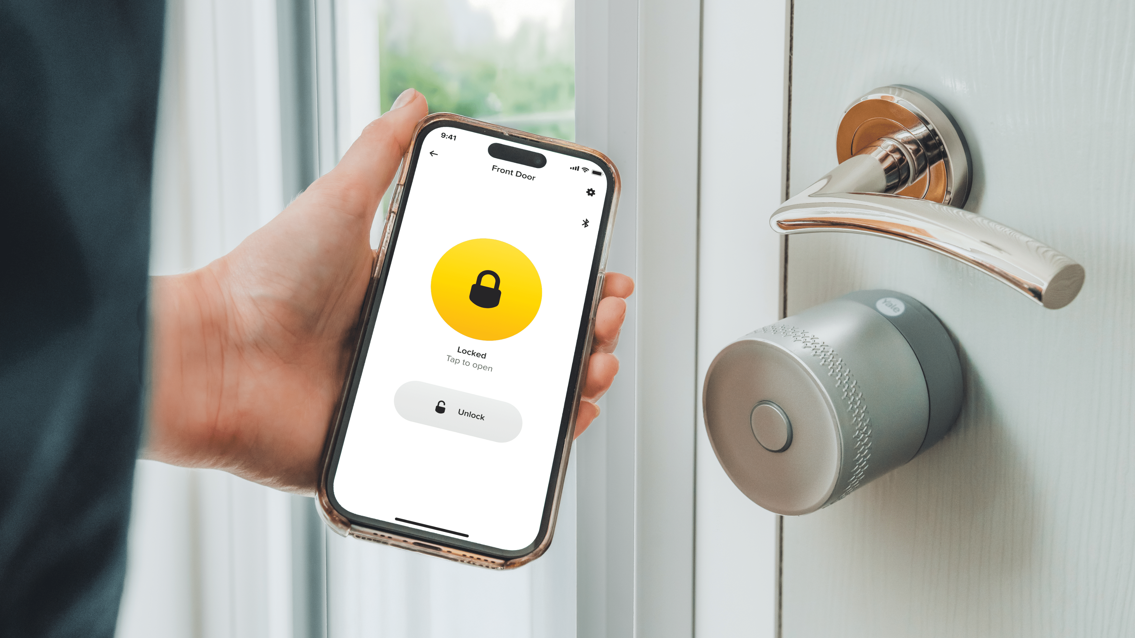 A person holding a phone displaying the Yale Linus Smart Lock app, showing it is locked.