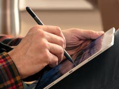 A person using the Zagg Pro Stylus to write something on an iPad