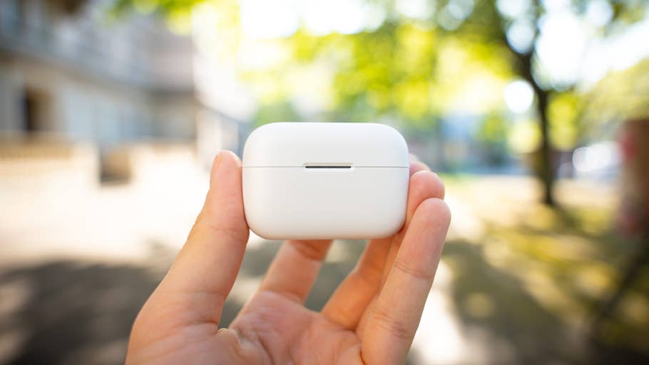A person holds an Anker Soundcore AeroClip charger outdoors.