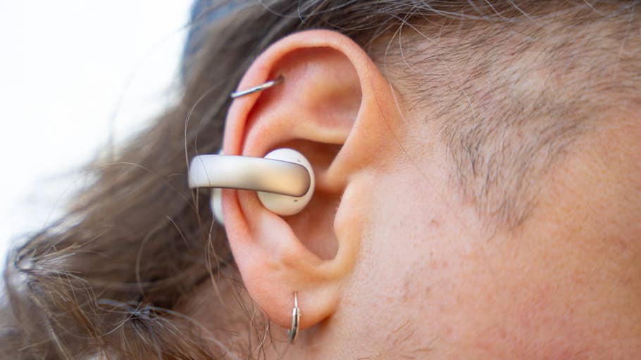 Close-up of an ear with an Anker Soundcore Aeroclip earbud plugged in.