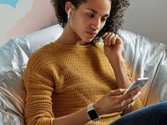A person sitting in a couch listening to music with AirPods