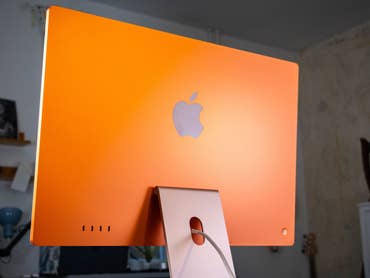 Orange Apple iMac M4 2024 from behind with visible Apple logo.