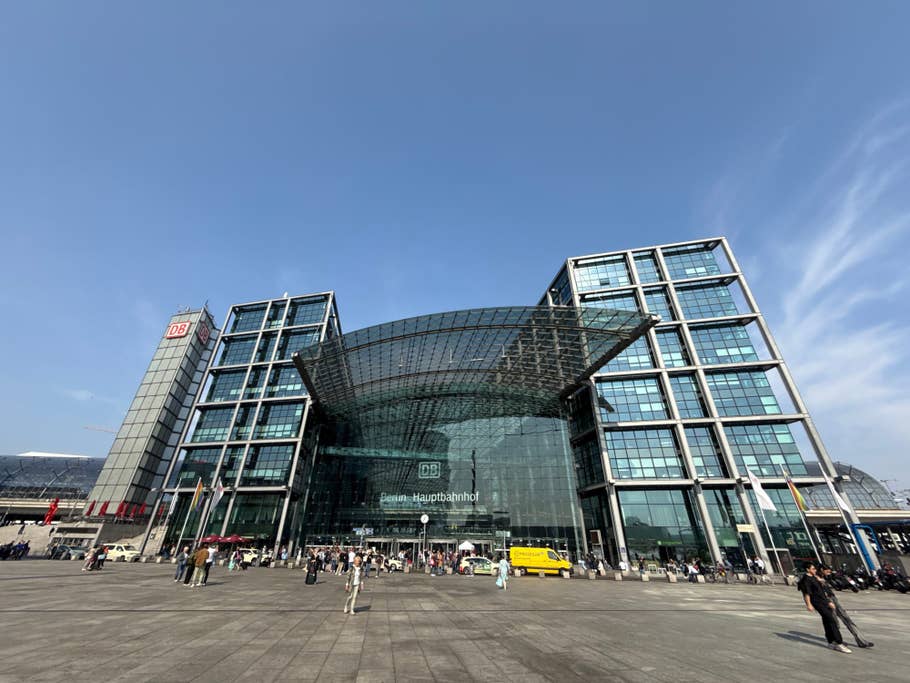 The Berlin Central Station in glass and people in the square.