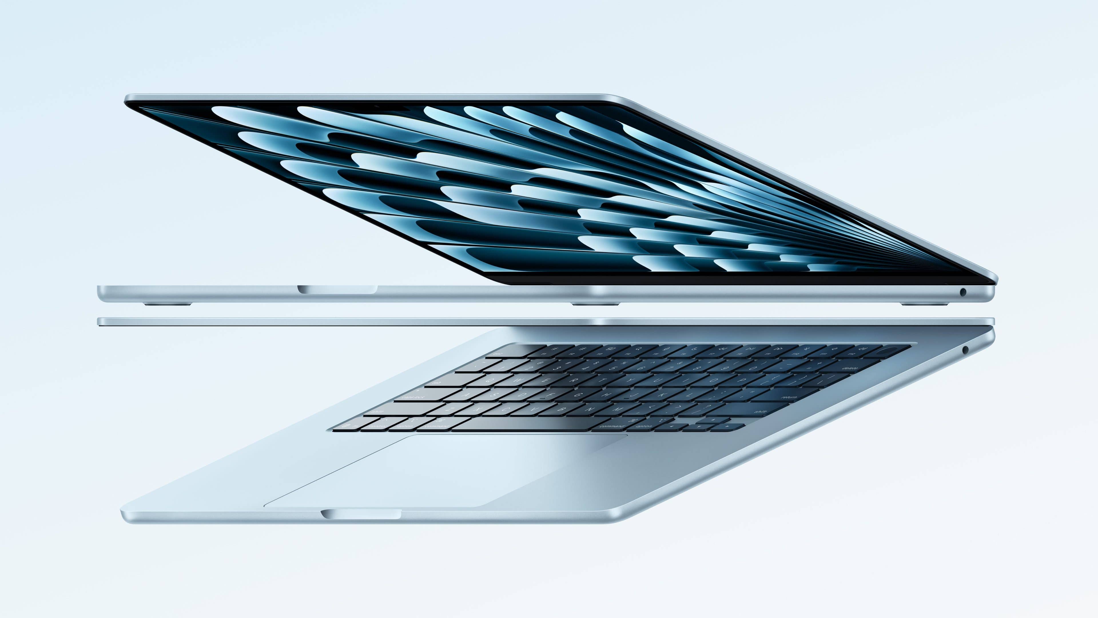 A sleek Apple laptop floating with its screen open and keyboard visible. A sleek Apple laptop floating with its screen open and keyboard visible.