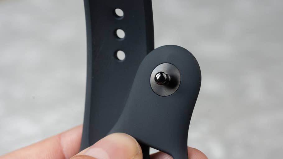 Close up of an Apple Watch SE 3 band being held showing the mounting pin and adjustment holes.
