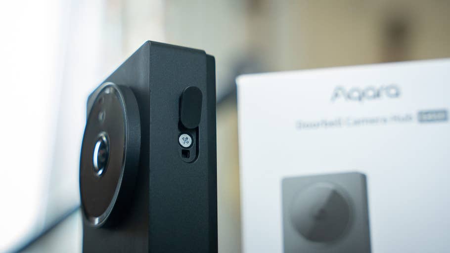 Aqara doorbell camera hub with a circular lens and side button, next to its packaging.