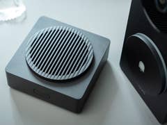 A close-up of the Aqara doorbell camera hub G410, featuring a round speaker with grooves and a black design.