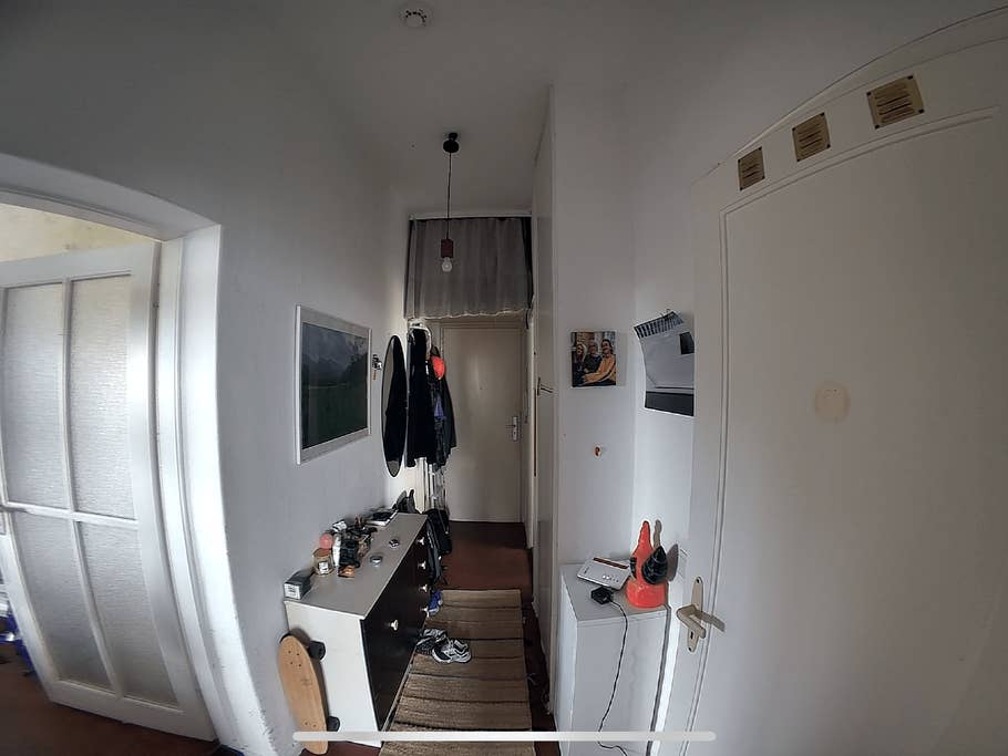 A hallway with a door, wall decorations, and a console table with items on it.