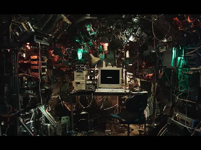 A crowded room with cables and monitors, a computer in the middle. Text: 'BLACK MIRROR'.