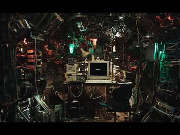 A crowded room with cables and monitors, a computer in the middle. Text: 'BLACK MIRROR'.