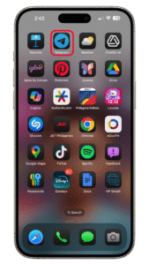 Navigate to the home screen and long press on the app you want to hide. iOS 18 home screen featuring various app icons including Telegram, Spotify, and Disney+.