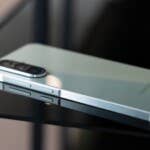 Here is the Samsung Galaxy A56, which, like the other devices, boasts a triple camera. A Samsung Galaxy A56 smartphone lies on a reflective black surface.