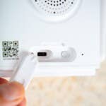 The USB-C port is used for charging, where the charging cable of the solar panel covers the port. Close-up of the USB-C port and QR code in the Reolink Atlas PT Ultra camera.