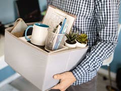 Man carrying a box of personal things after being fired.