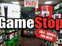 The game stop logo in front of boxed consoles inside of a store.