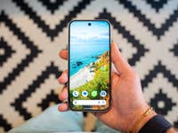 Google's Pixel 9 has a brigher and slightly wider 6.3-inch OLED display. A hand holding a Google Pixel 9 smartphone displaying a beach wallpaper.