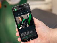 A person holding an Apple iPhone 15 Pro Max displaying a WhatsApp chat with an image.