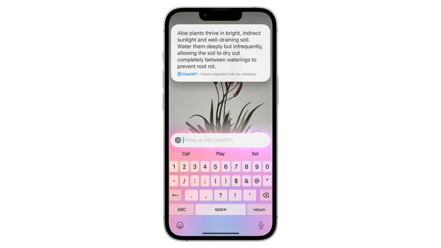 A close-up of an iPhone 16E displaying a message about caring for aloe plants with a soft pink keyboard.