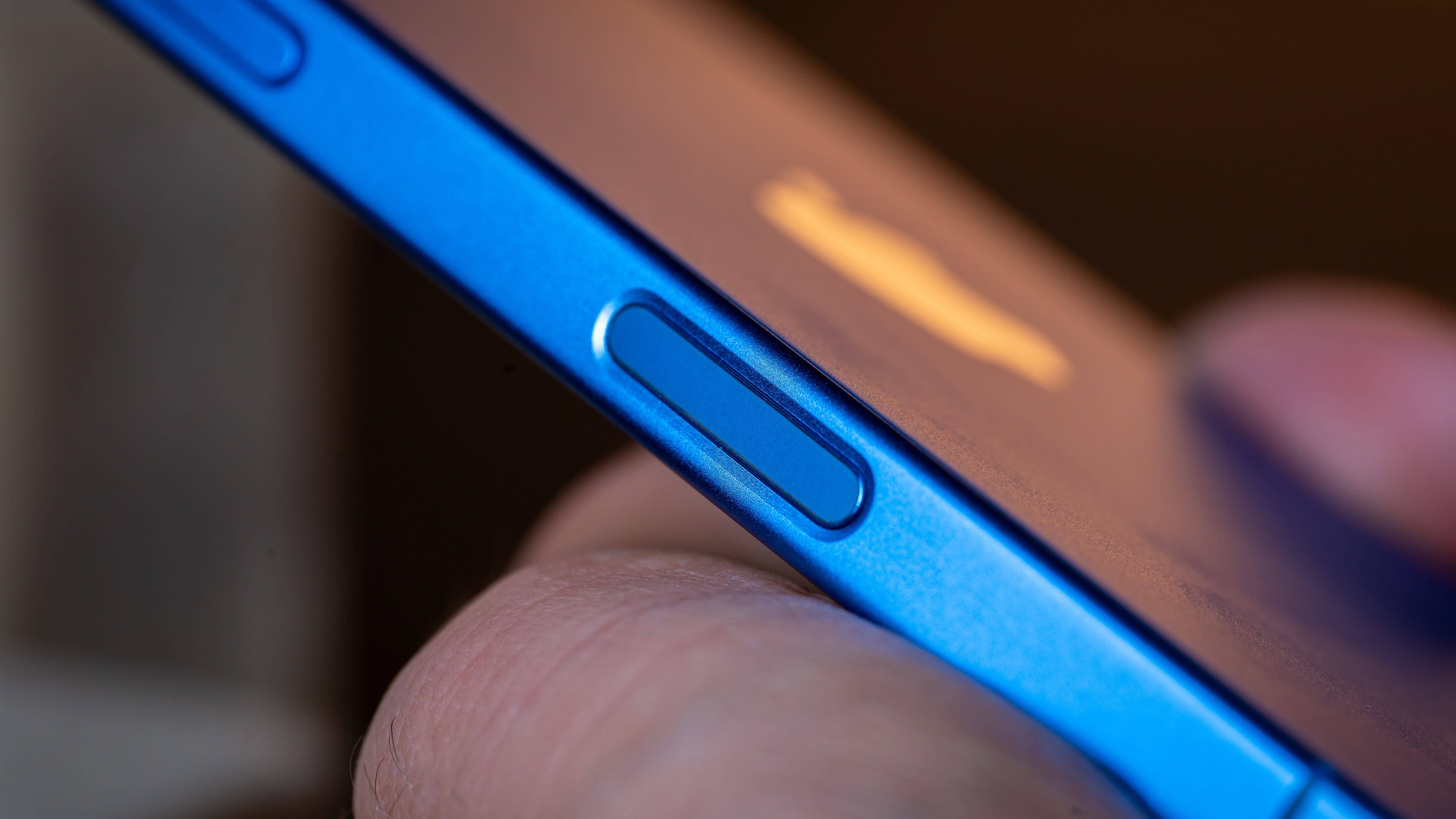 Close-up of a blue iPhone 16 side with a volume button.