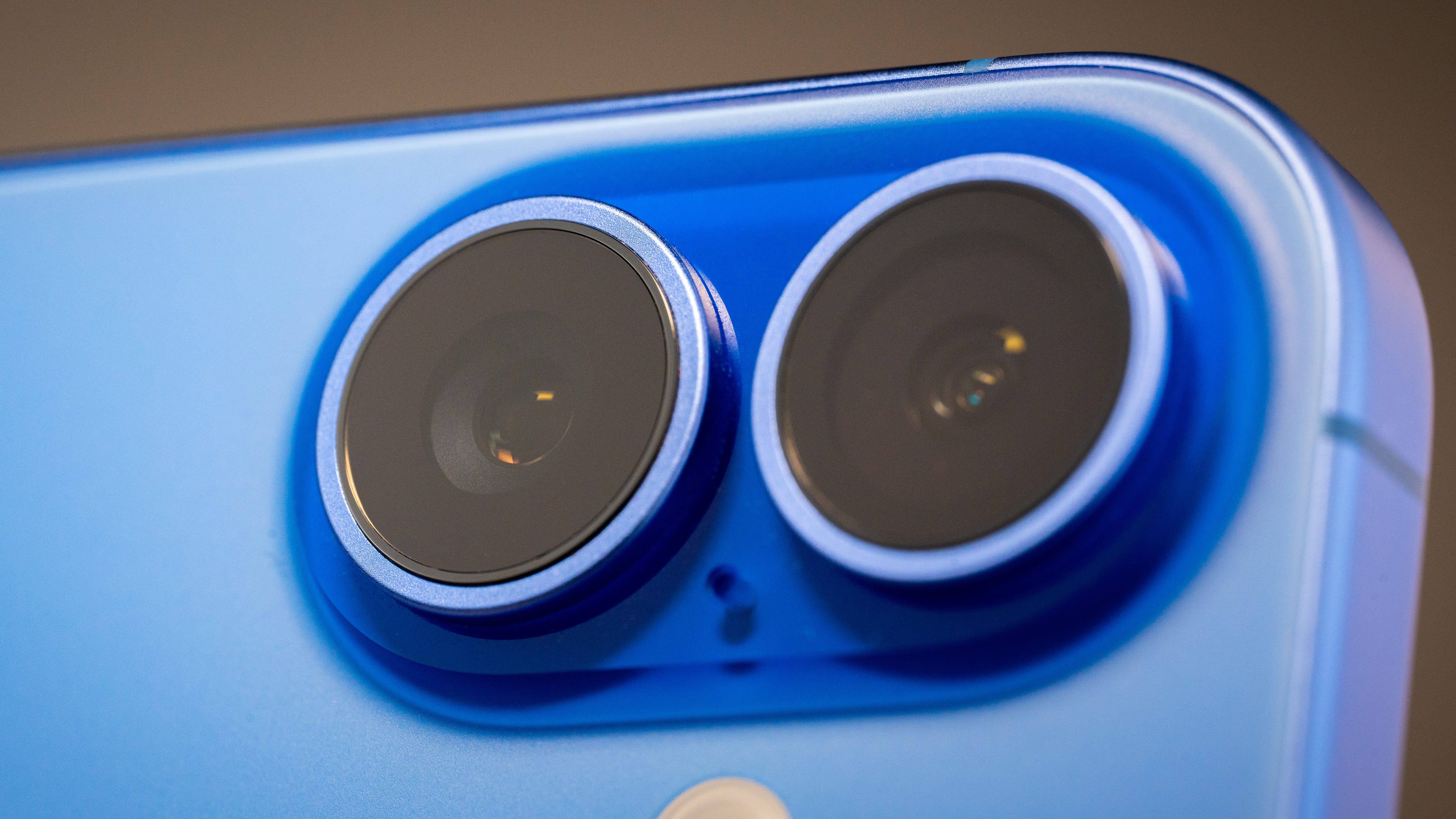 Close-up of the dual camera lenses on a blue Apple iPhone 16.