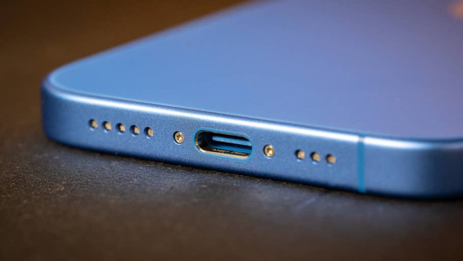 Close-up of an Apple iPhone 16 showing the charging port and speaker grilles.
