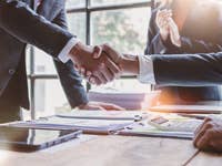 Persons shaking hands in the office over a good deal