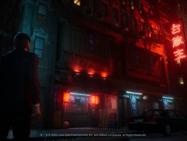John Wick is standing in front of a store with neon lights in the rain.