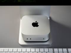 A silver Apple Mac Mini M4 Pro on a stand, with a keyboard in the foreground.