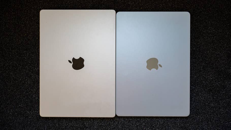 Two Apple MacBook Air laptops side by side, one with a black logo and the other with a gold logo.
