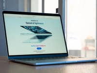 A MacBook Air displaying 'Speed of lightness' and 'Built for Apple Intelligence' on its screen.