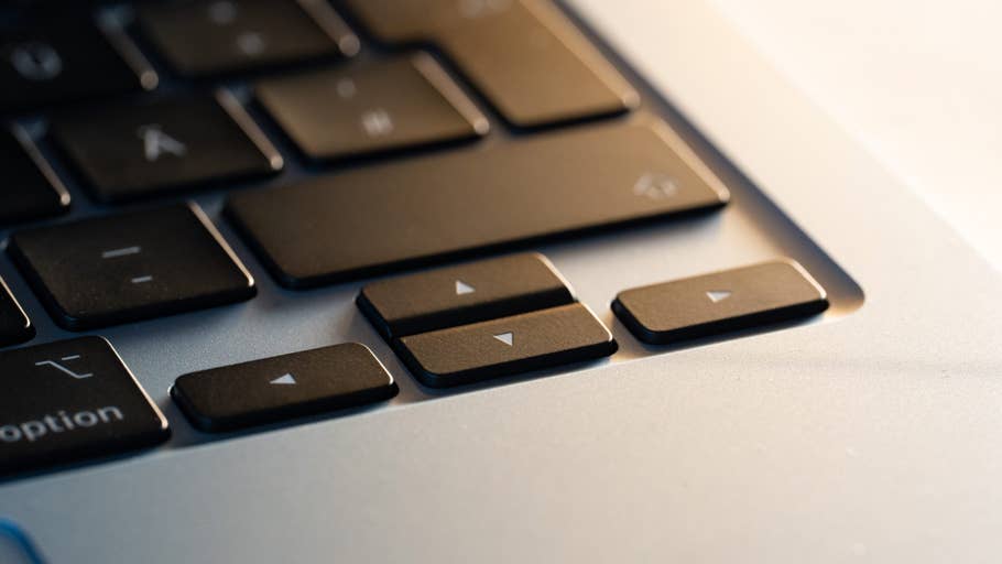 Close-up of an Apple MacBook Air keyboard, focusing on the arrow keys and some other function keys.