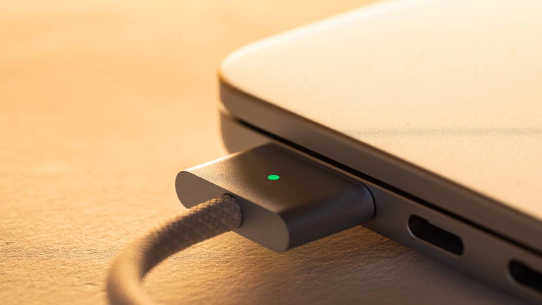 Close-up of a MacBook Air M4 charging port with a green light indicator.