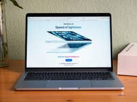 Apple MacBook Air displaying 'Speed of lightness.' with a sleek design on a wooden table.