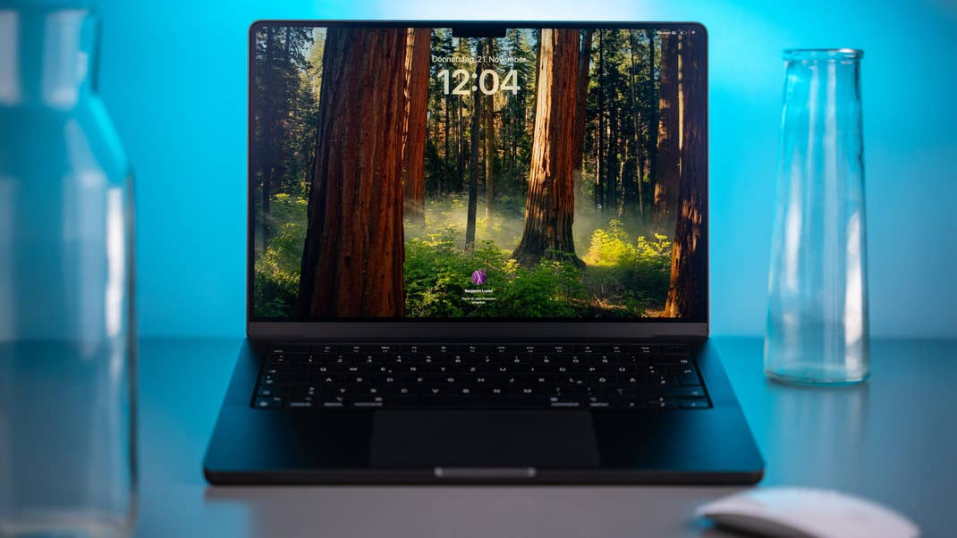 Apple MacBook Pro M4 with a forest wallpaper showing the time 12:04.