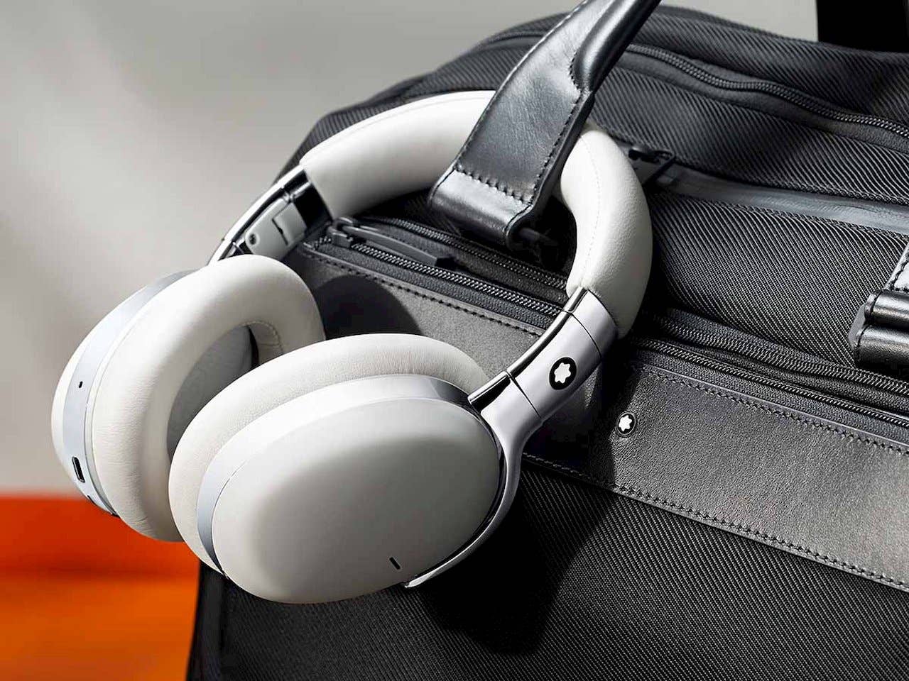 A Montblanc wireless headphone attached to a purse A Montblanc wireless headphone attached to a purse