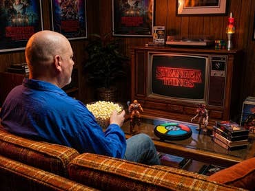 Casi sits on the couch in his 80s living room and watches Stranger Things