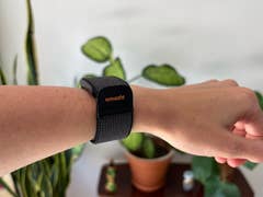A close-up of a wrist with a black Amazfit Helio strap on it.