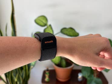 A close-up of a wrist with a black Amazfit Helio strap on it.