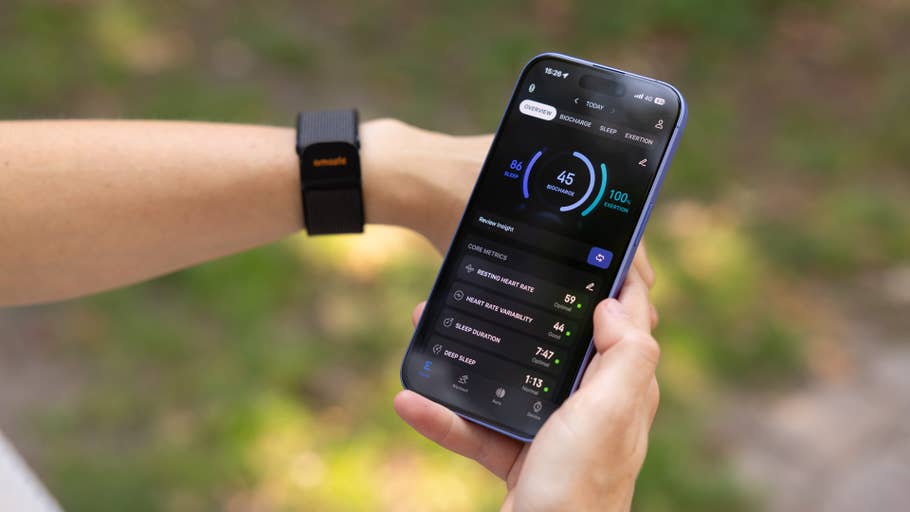 A person checking health metrics on a smartphone, wearing an Amazfit Helio strap on their wrist.