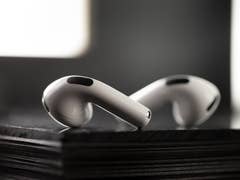 Close-up of Apple AirPods resting on a black surface, showcasing their sleek design.