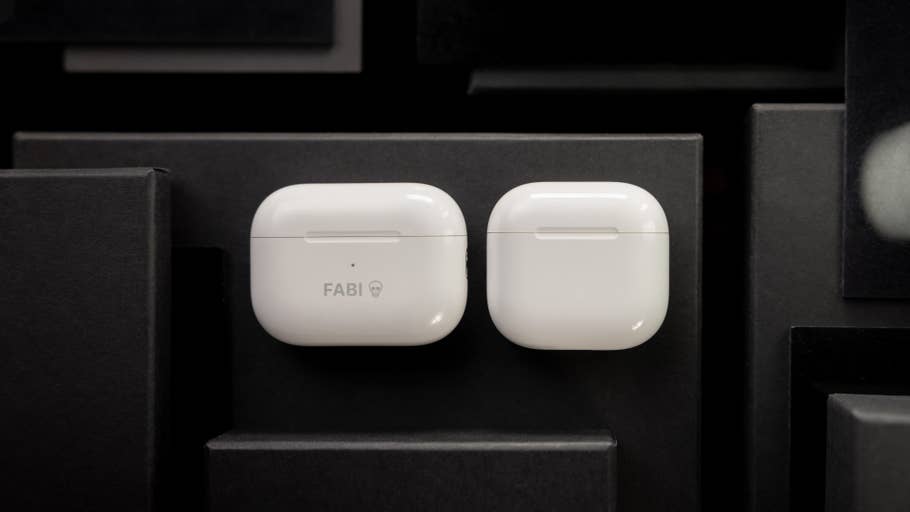 White Apple AirPods cases on a dark background, one with u0027FABIu0027 text.