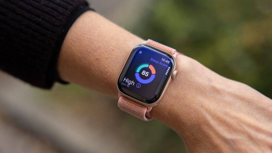 A close-up of an Apple Watch displaying a sleep score of 85 on a person's wrist.
